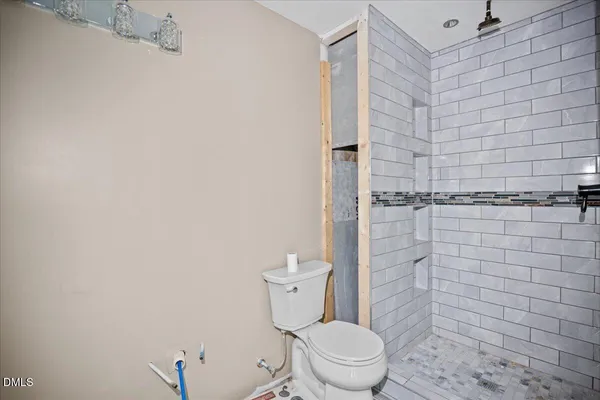 a white toilet sitting next to a shower
