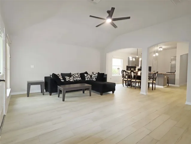 a living room with furniture and a dining table with kitchen view