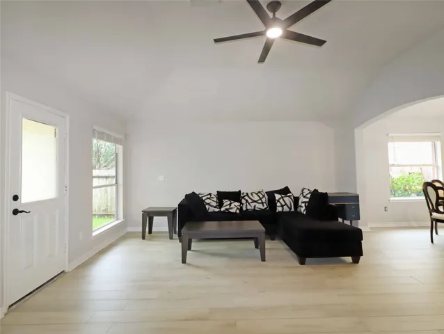 a living room with furniture and a wooden floor