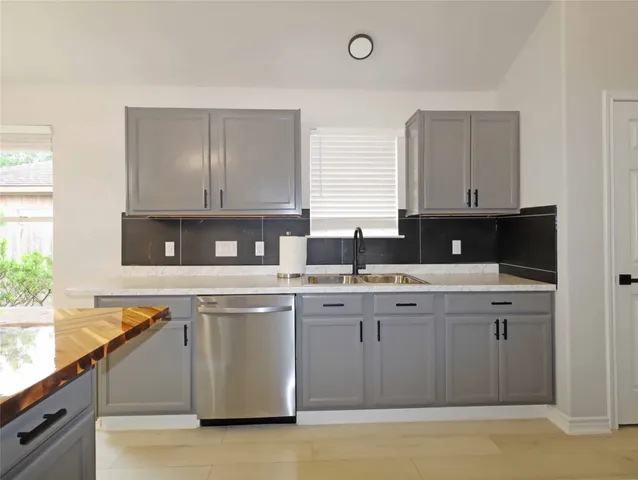 a kitchen with stainless steel appliances granite countertop a sink a stove and cabinets