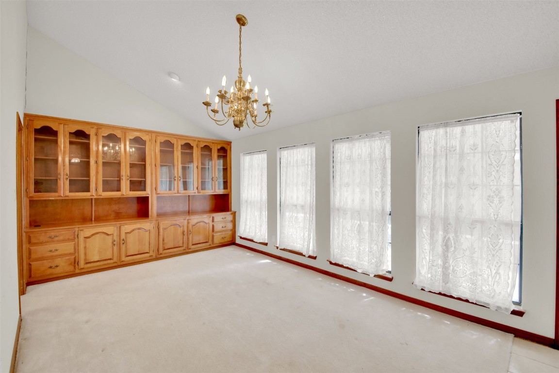1403 Stone Ridge Drive Taylor, TX 76574 - Photo 14 of 39 Unfurnished dining area featuring vaulted ceiling, light colored carpet, and a chandelier