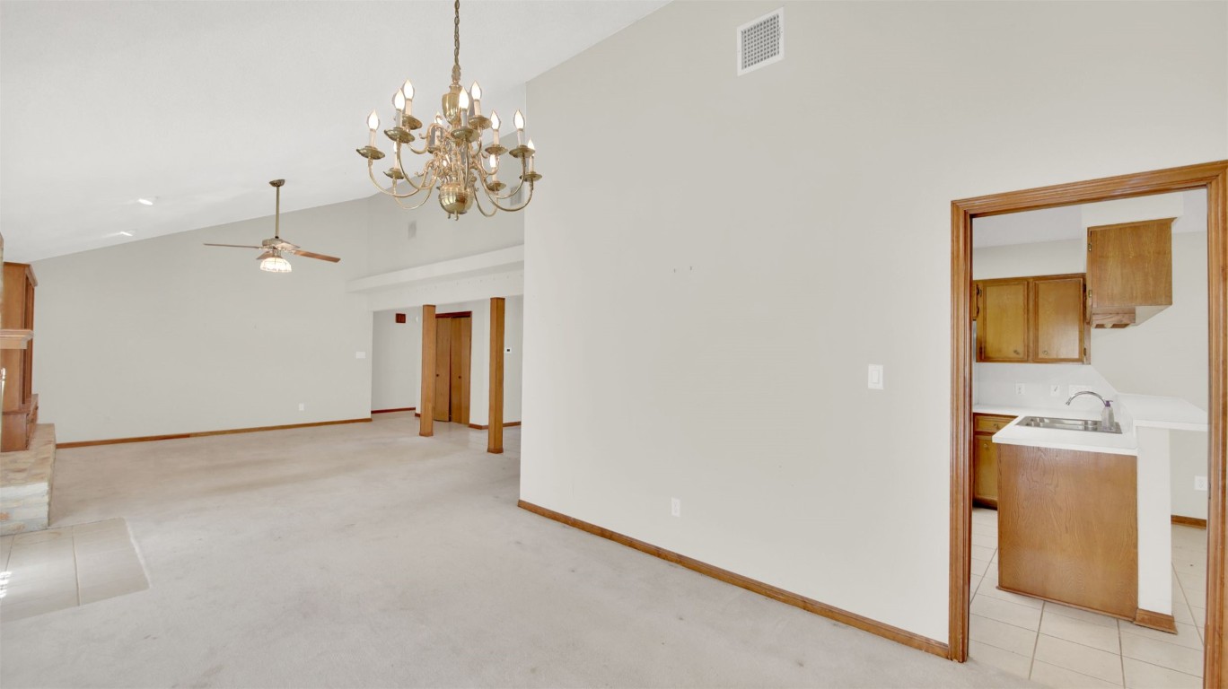 1403 Stone Ridge Drive Taylor, TX 76574 - Photo 15 of 39 Spare room with a ceiling fan, a chandelier, light carpet, high vaulted ceiling, and light tile patterned flooring