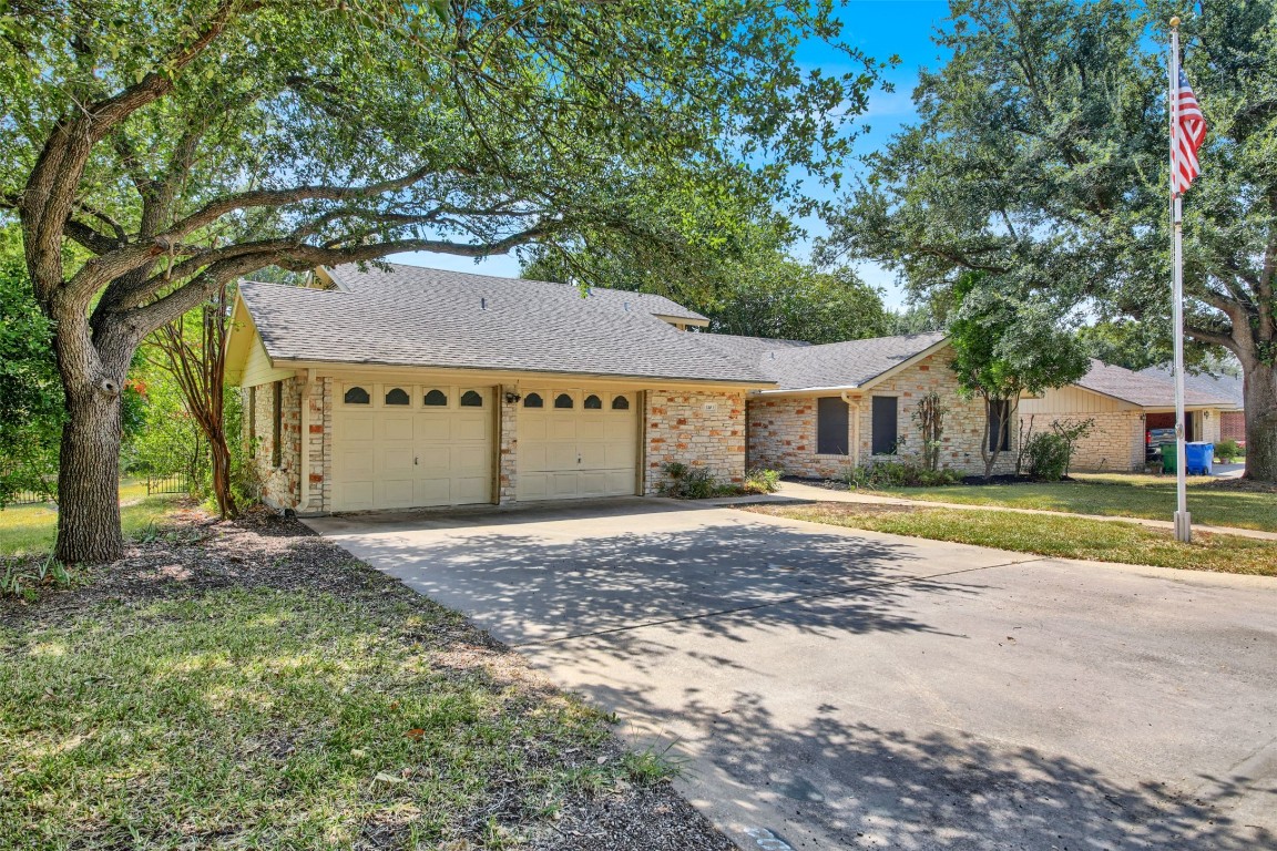 1403 Stone Ridge Drive Taylor, TX 76574 - Photo 2 of 39 Ranch-style house with a shingled roof, a front lawn, driveway, and an attached garage