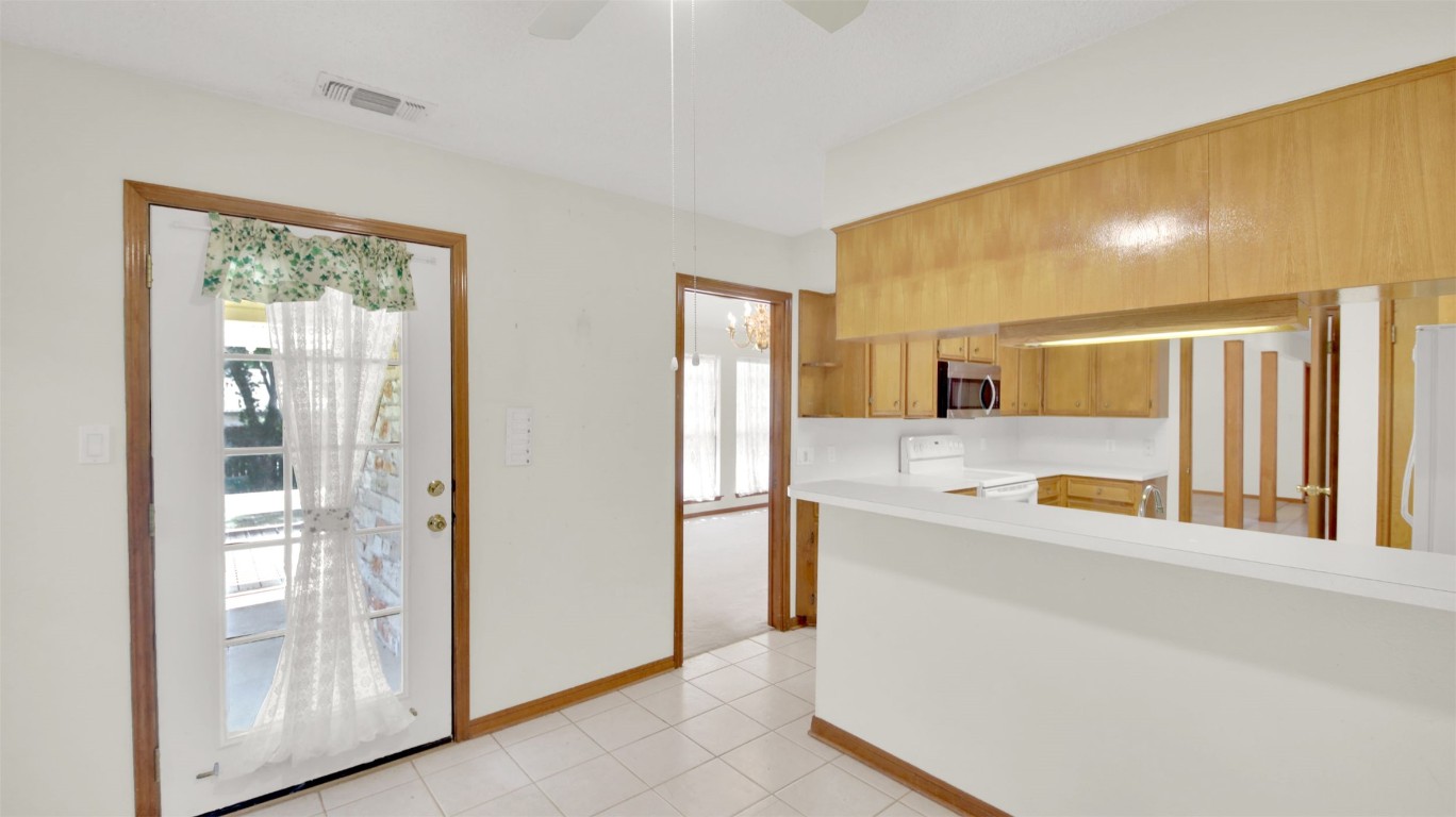 1403 Stone Ridge Drive Taylor, TX 76574 - Photo 21 of 39 Kitchen with light countertops, white appliances, light tile patterned flooring, and a ceiling fan