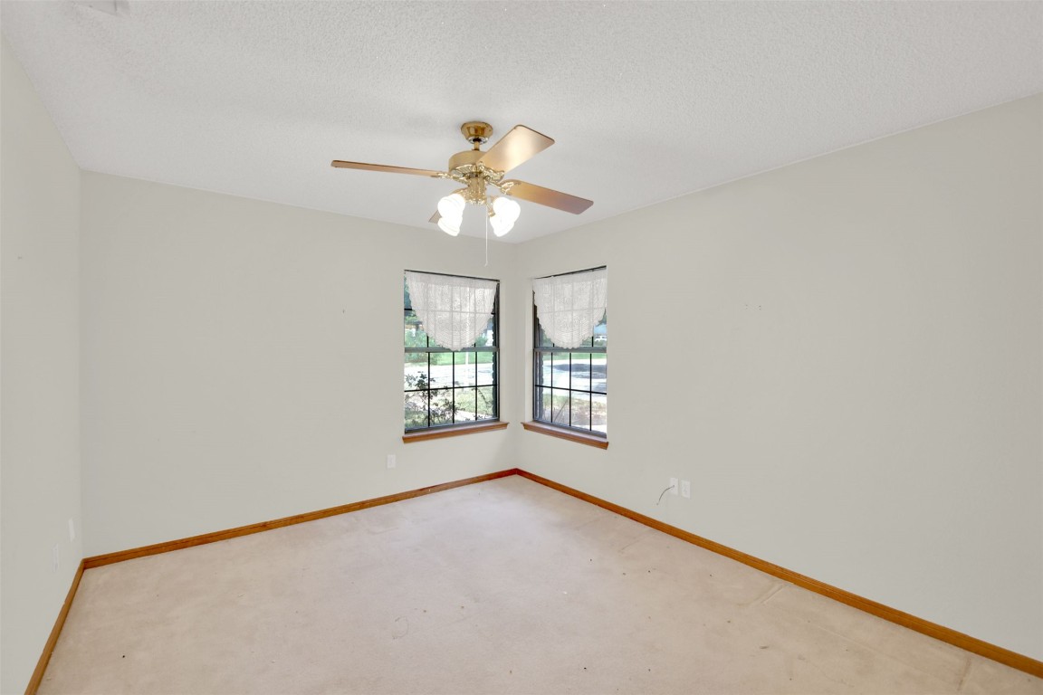 1403 Stone Ridge Drive Taylor, TX 76574 - Photo 23 of 39 Carpeted empty room featuring a textured ceiling and a ceiling fan