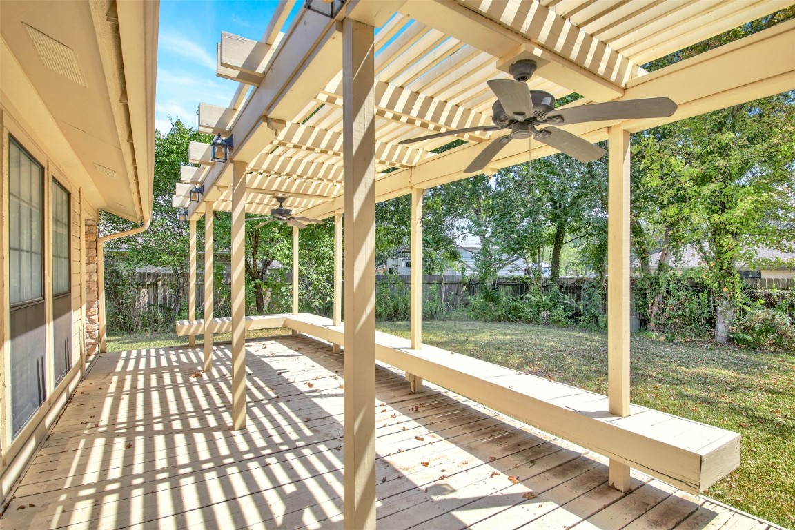 1403 Stone Ridge Drive Taylor, TX 76574 - Photo 33 of 39 Wooden deck with ceiling fan, a pergola, and a fenced backyard