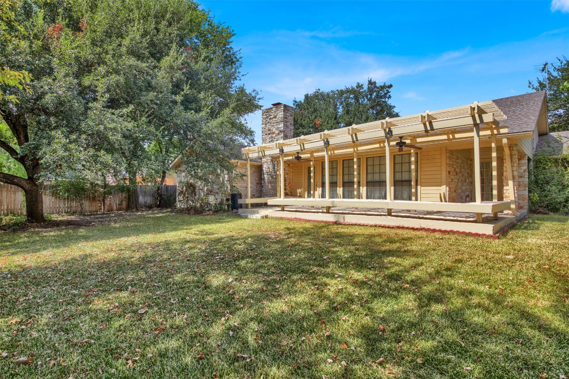 1403 Stone Ridge Drive Taylor, TX 76574 - Photo 38 of 39 Rear view of house with a pergola, stone siding, a chimney, and a patio