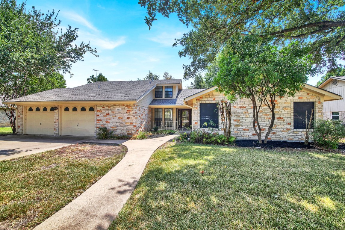 1403 Stone Ridge Drive Taylor, TX 76574 - Photo 4 of 39 View of front of home with roof with shingles, stone siding, a front yard, and driveway