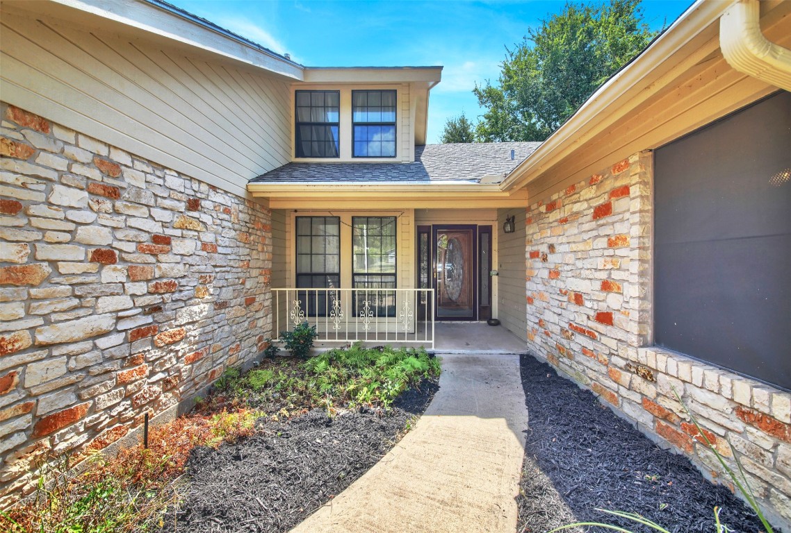 1403 Stone Ridge Drive Taylor, TX 76574 - Photo 5 of 39 View of exterior entry with stone siding and roof with shingles