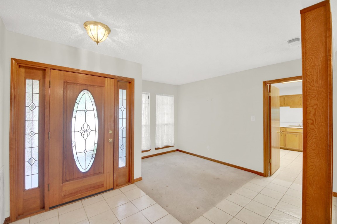 1403 Stone Ridge Drive Taylor, TX 76574 - Photo 7 of 39 Entrance foyer with light tile patterned floors, light carpet, and a textured ceiling