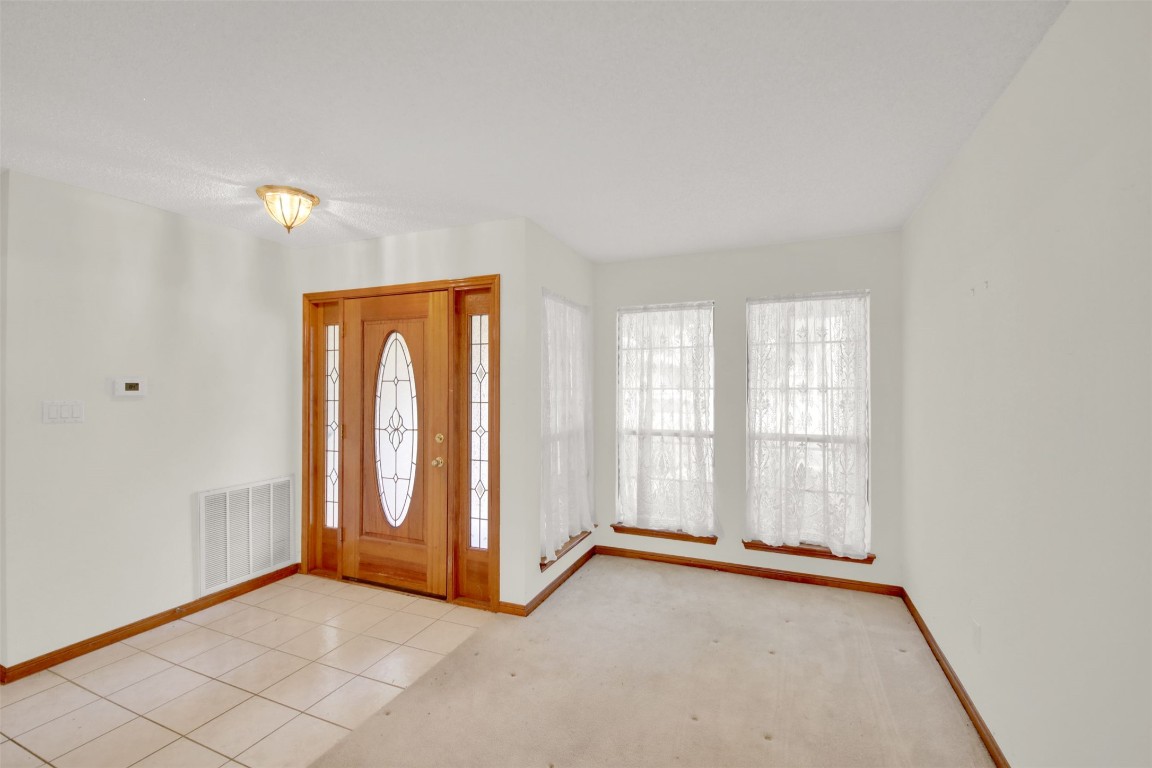 1403 Stone Ridge Drive Taylor, TX 76574 - Photo 8 of 39 Entryway with healthy amount of natural light, light tile patterned floors, and light carpet