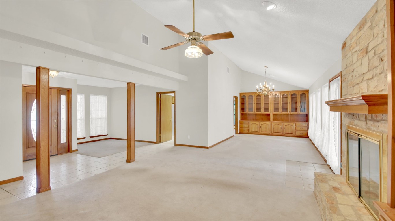 1403 Stone Ridge Drive Taylor, TX 76574 - Photo 10 of 39 Unfurnished living room featuring light colored carpet, healthy amount of natural light, high vaulted ceiling, a chandelier, and light tile patterned flooring