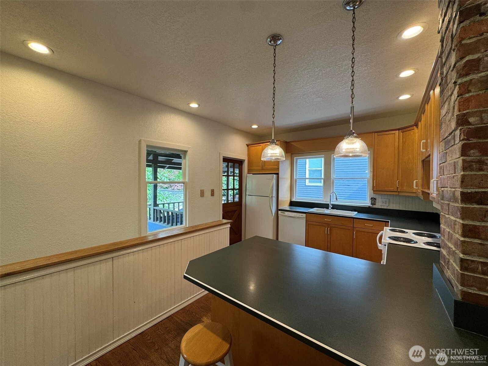 4521 49th Avenue Northeast Seattle, WA 98105 - Photo 5 of 20 a kitchen with stainless steel appliances granite countertop a sink a stove and a wooden floors