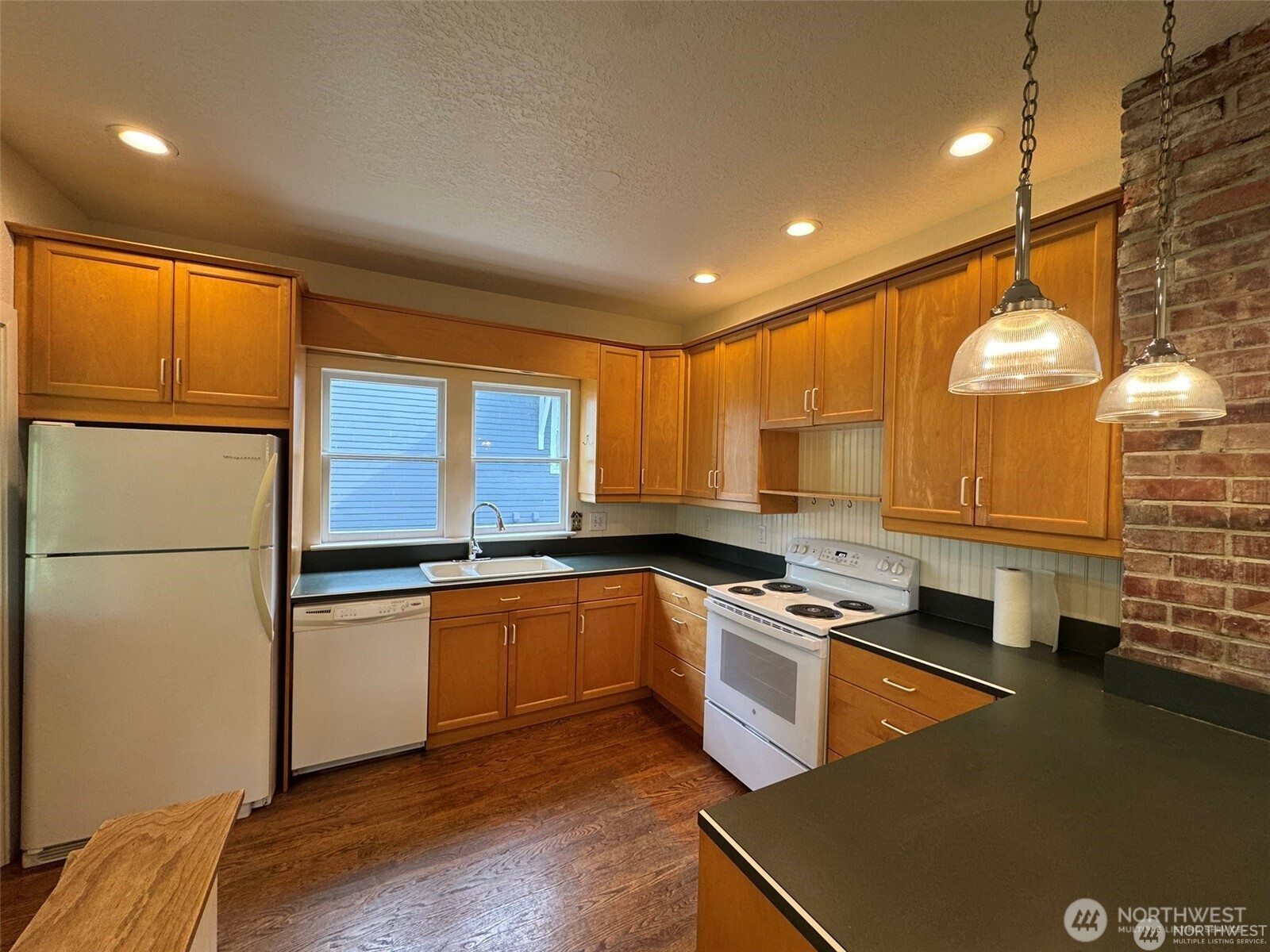 4521 49th Avenue Northeast Seattle, WA 98105 - Photo 6 of 20 a kitchen with stainless steel appliances granite countertop a sink a stove and a refrigerator