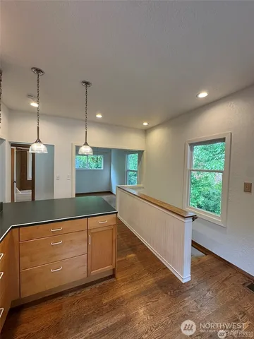 a kitchen with stainless steel appliances granite countertop a sink a microwave oven a refrigerator and white cabinets