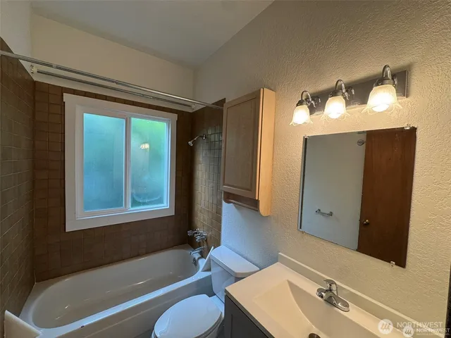 a bathroom with a tub shower and sink