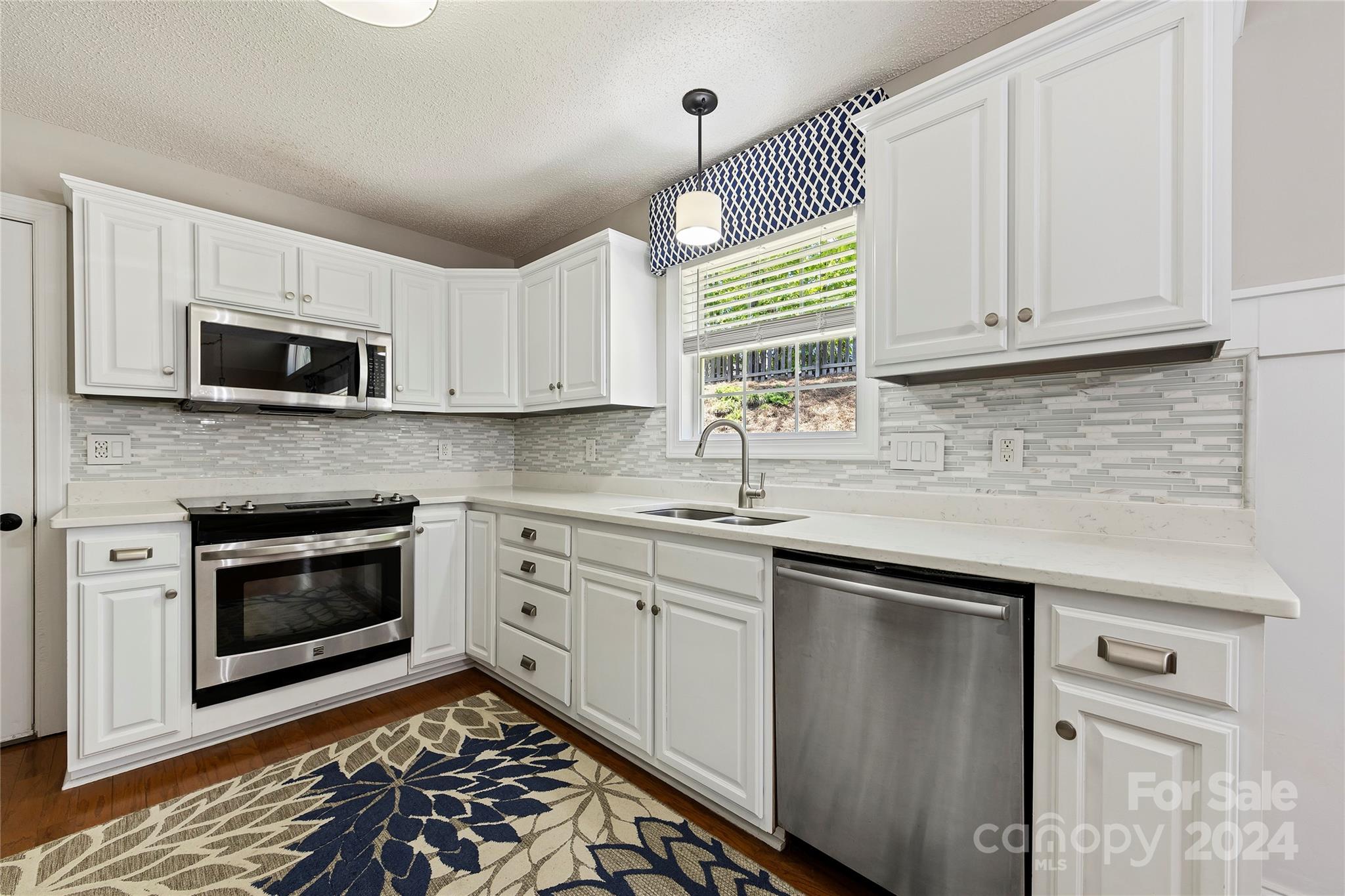 1313 Crown Ridge Drive Fort Mill, SC 29708 - Photo 11 of 35 a kitchen with stainless steel appliances granite countertop a sink a stove a microwave and cabinets