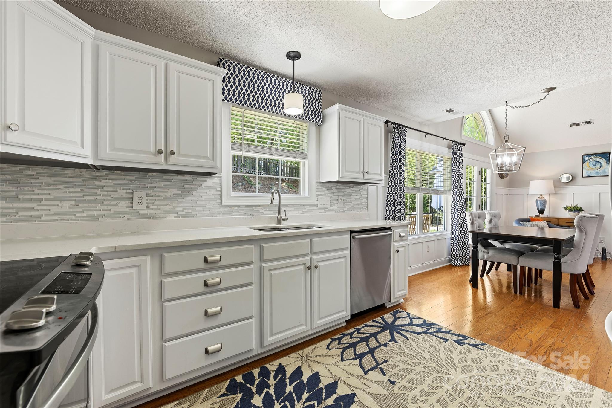 1313 Crown Ridge Drive Fort Mill, SC 29708 - Photo 10 of 35 a kitchen with stainless steel appliances granite countertop a stove a sink dishwasher and white cabinets with wooden floor