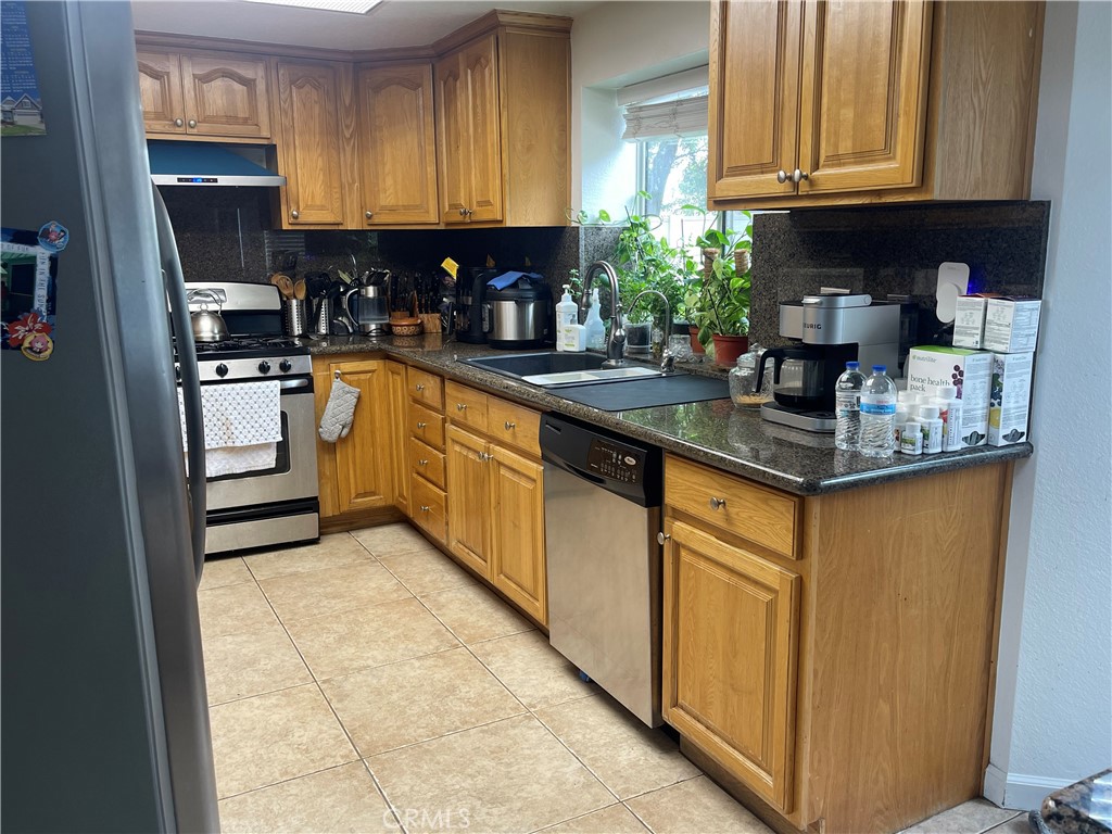 22740 Main Street Grand Terrace, CA 92313 - Photo 11 of 30 a kitchen with stainless steel appliances granite countertop a stove sink and cabinets