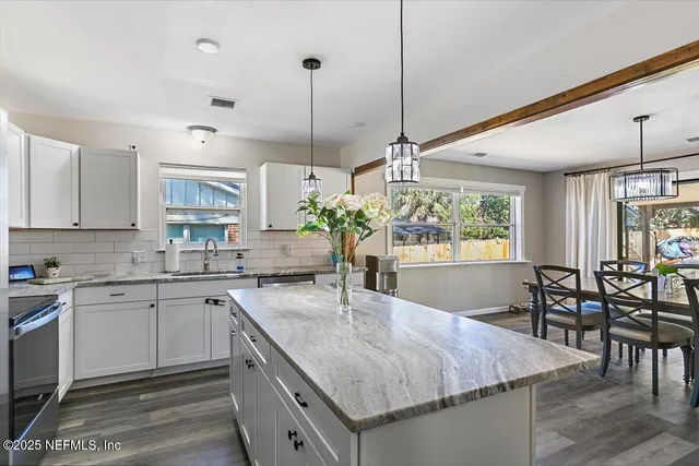 a kitchen with kitchen island granite countertop a table and chairs in it