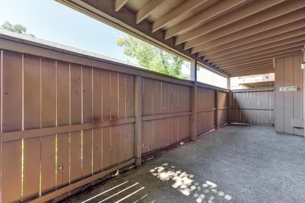 an empty room with wooden floor fireplace and windows