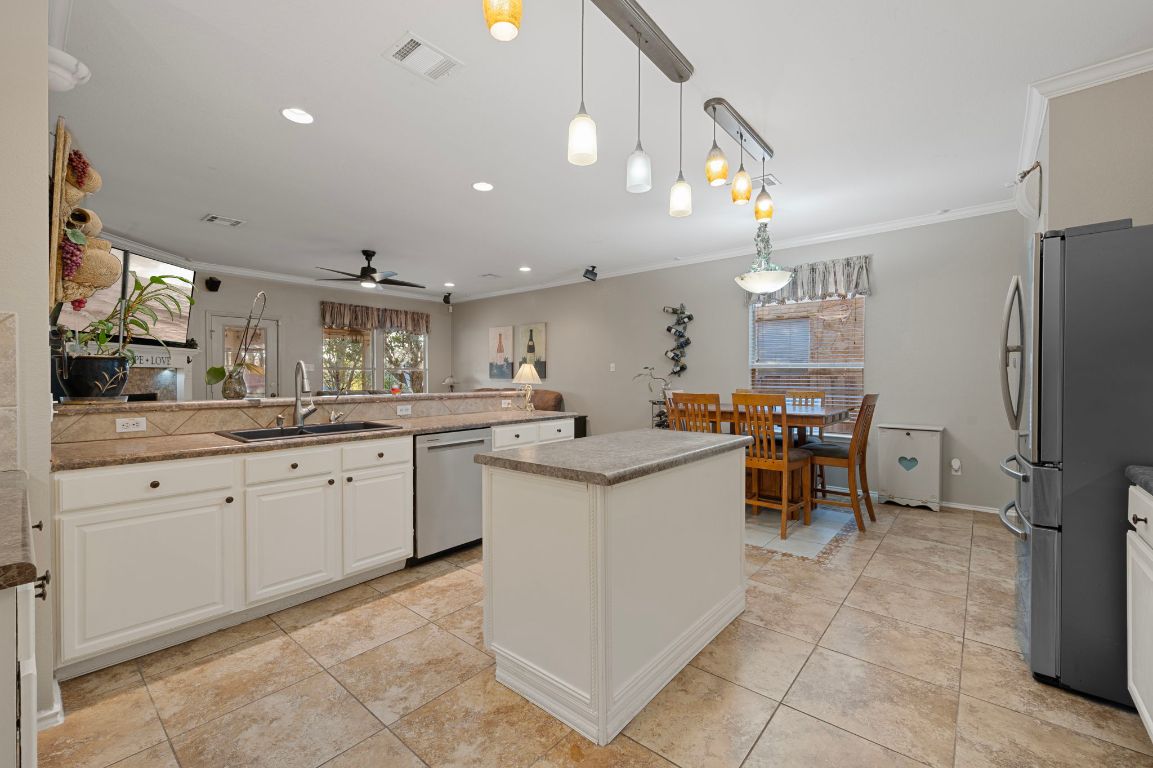 17813 Floribundas Lane Elgin, TX 78621 - Photo 12 of 39 a kitchen with granite countertop cabinets a sink a counter top space and stainless steel appliances