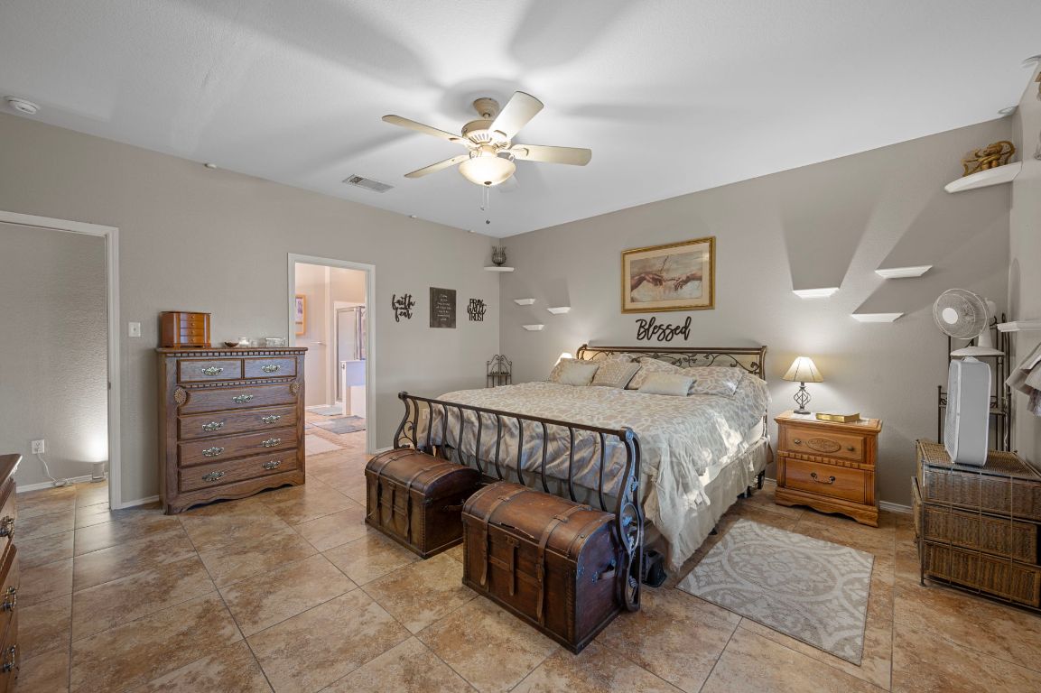 17813 Floribundas Lane Elgin, TX 78621 - Photo 17 of 39 a spacious bedroom with a bed and a chandelier