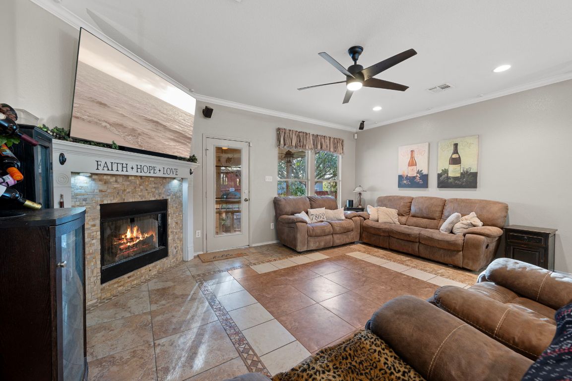 17813 Floribundas Lane Elgin, TX 78621 - Photo 7 of 39 a living room with furniture a fireplace and a ceiling fan