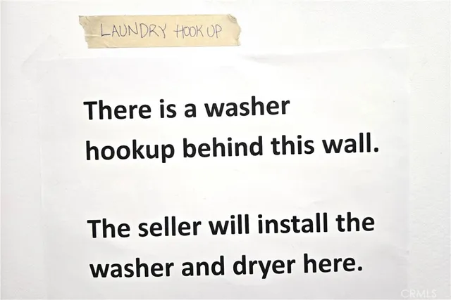 a view of empty room with wooden floor and bathroom