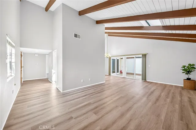 a view of an empty room with wooden floor