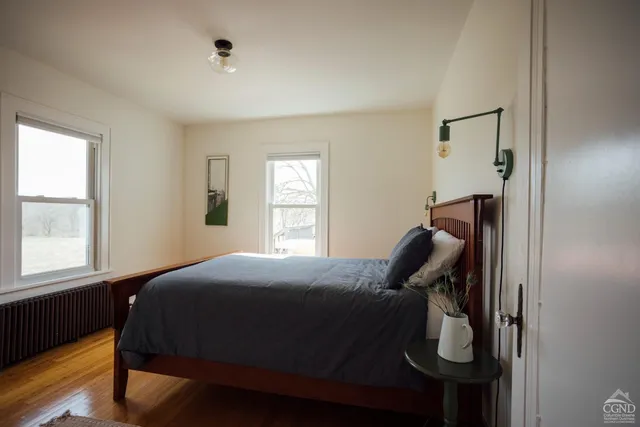 a bedroom with a bed and wooden floor