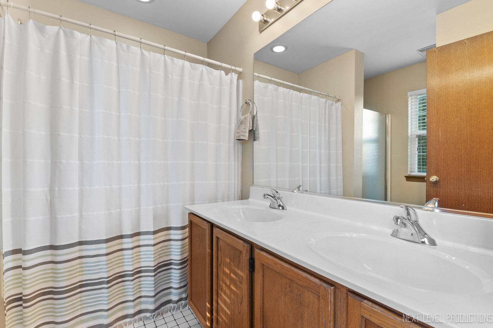 1683 Kautz Road Aurora, IL 60504 - Photo 16 of 26 a bathroom with a double vanity sink and a mirror
