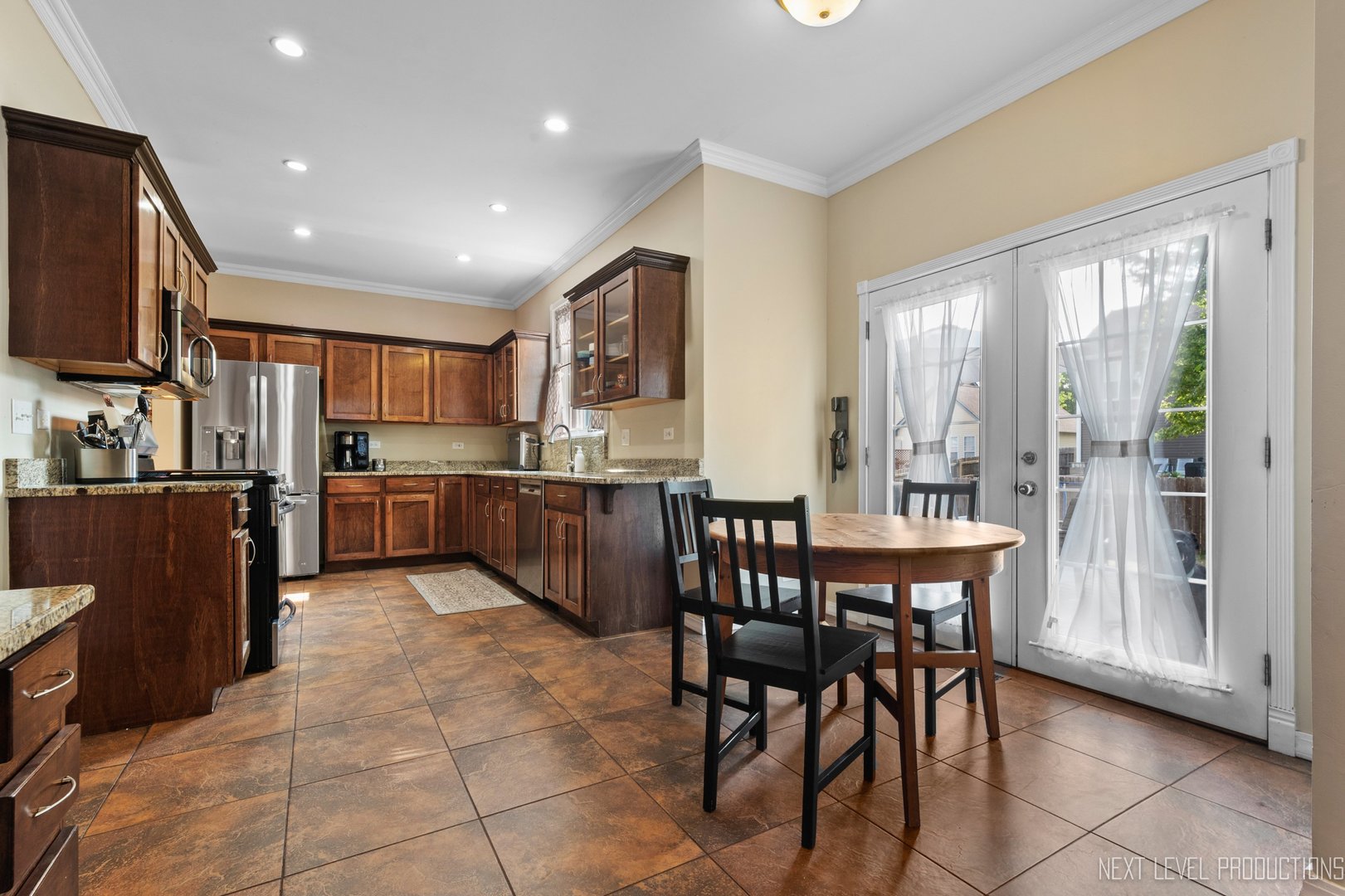 1683 Kautz Road Aurora, IL 60504 - Photo 5 of 26 a open dining room with stainless steel appliances kitchen island granite countertop a table and chairs