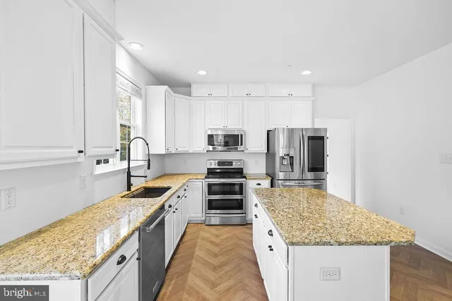 a large kitchen with a stove sink and refrigerator