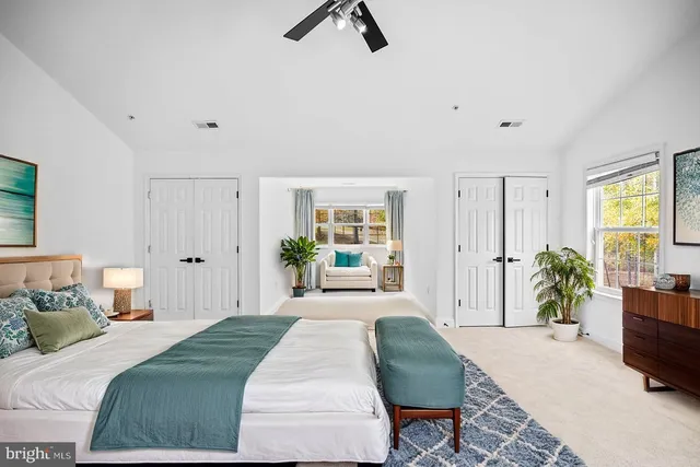 a spacious bedroom with a bed and a chandelier