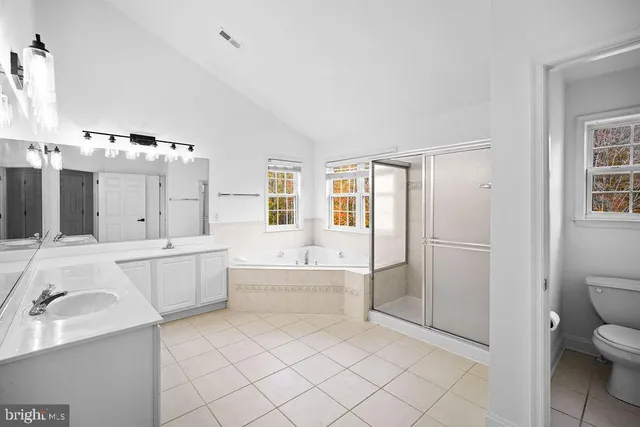 a large white bathroom with a large tub a sink a toilet and a shower