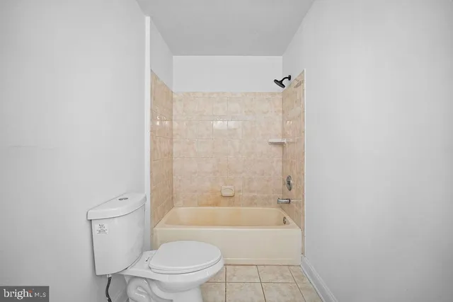 a bathroom with a granite countertop toilet a sink and bathtub