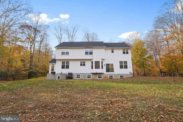 a view of a house with a big yard and large trees