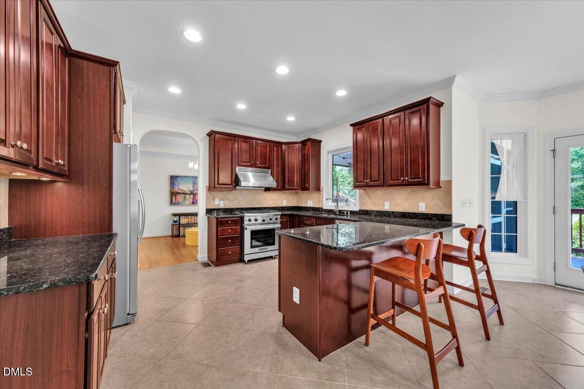 2908 Oak Bridge Drive Raleigh, NC 27610 - Photo 15 of 47 a kitchen with stainless steel appliances granite countertop wooden cabinets a stove top oven a sink and dishwasher