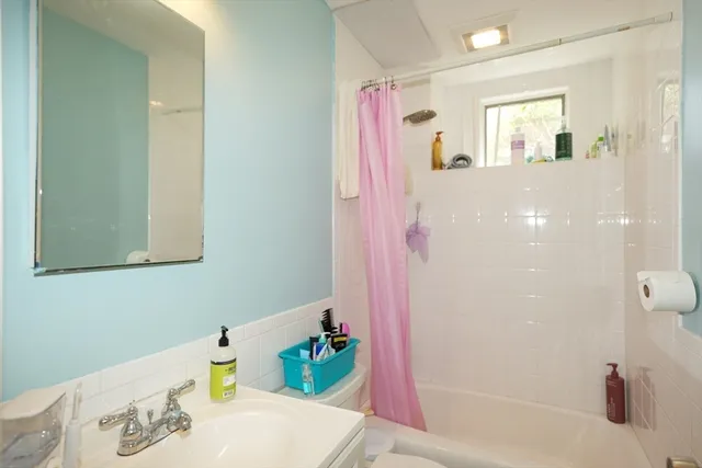 a bathroom with a tub shower sink and cabinets
