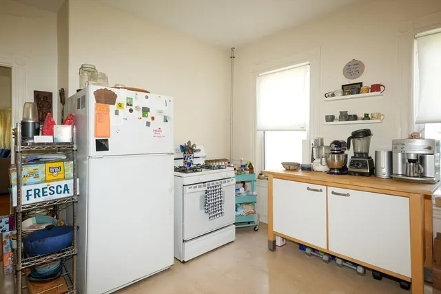 a kitchen with a refrigerator and a stove top oven