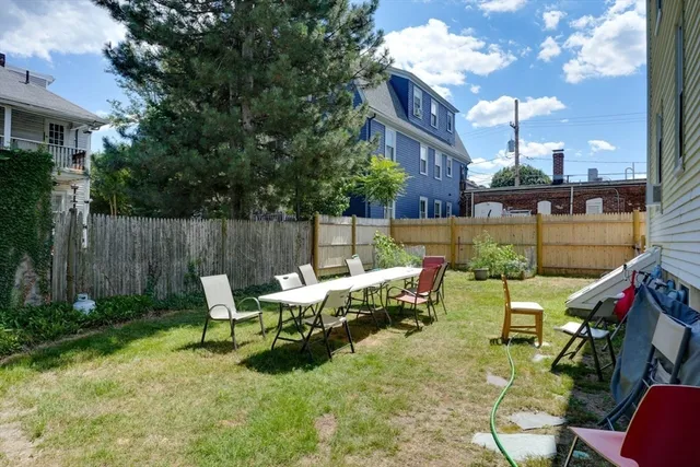 a backyard of a house with table and chairs