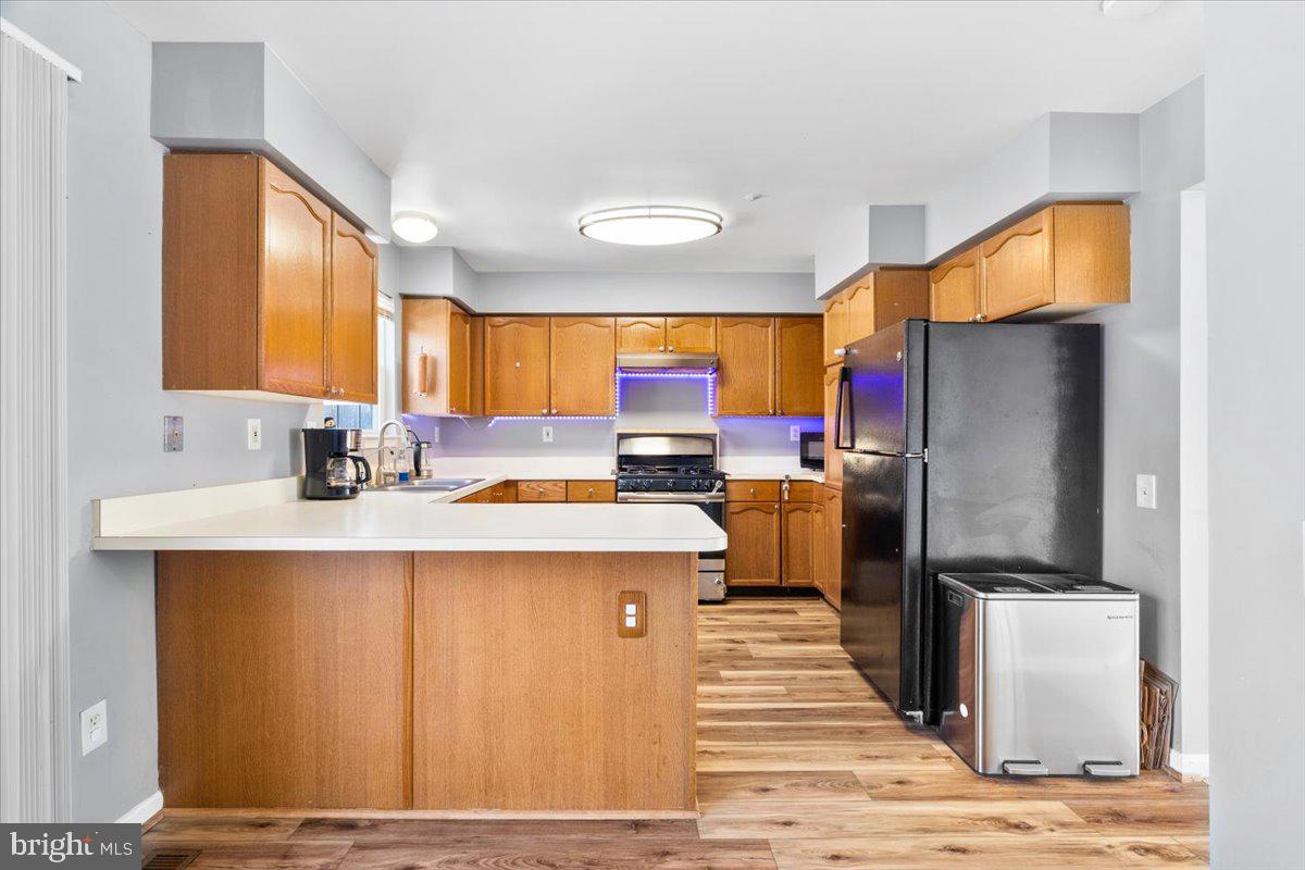 5636 Ashburn Terrace Frederick, MD 21703 - Photo 15 of 44 a kitchen with stainless steel appliances kitchen island granite countertop a refrigerator oven a sink dishwasher and a stove with wooden floor