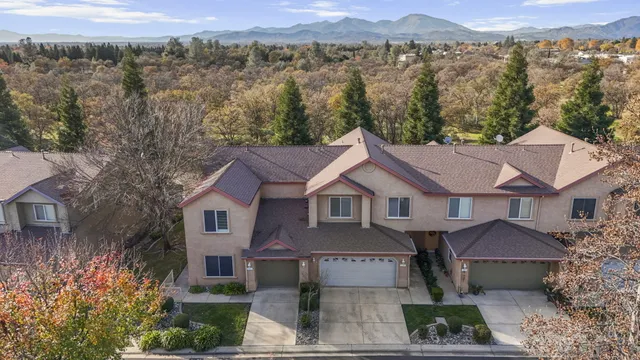 a front view of a house with a yard and mountain view
