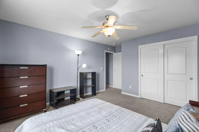 a bedroom with a bed and a ceiling fan