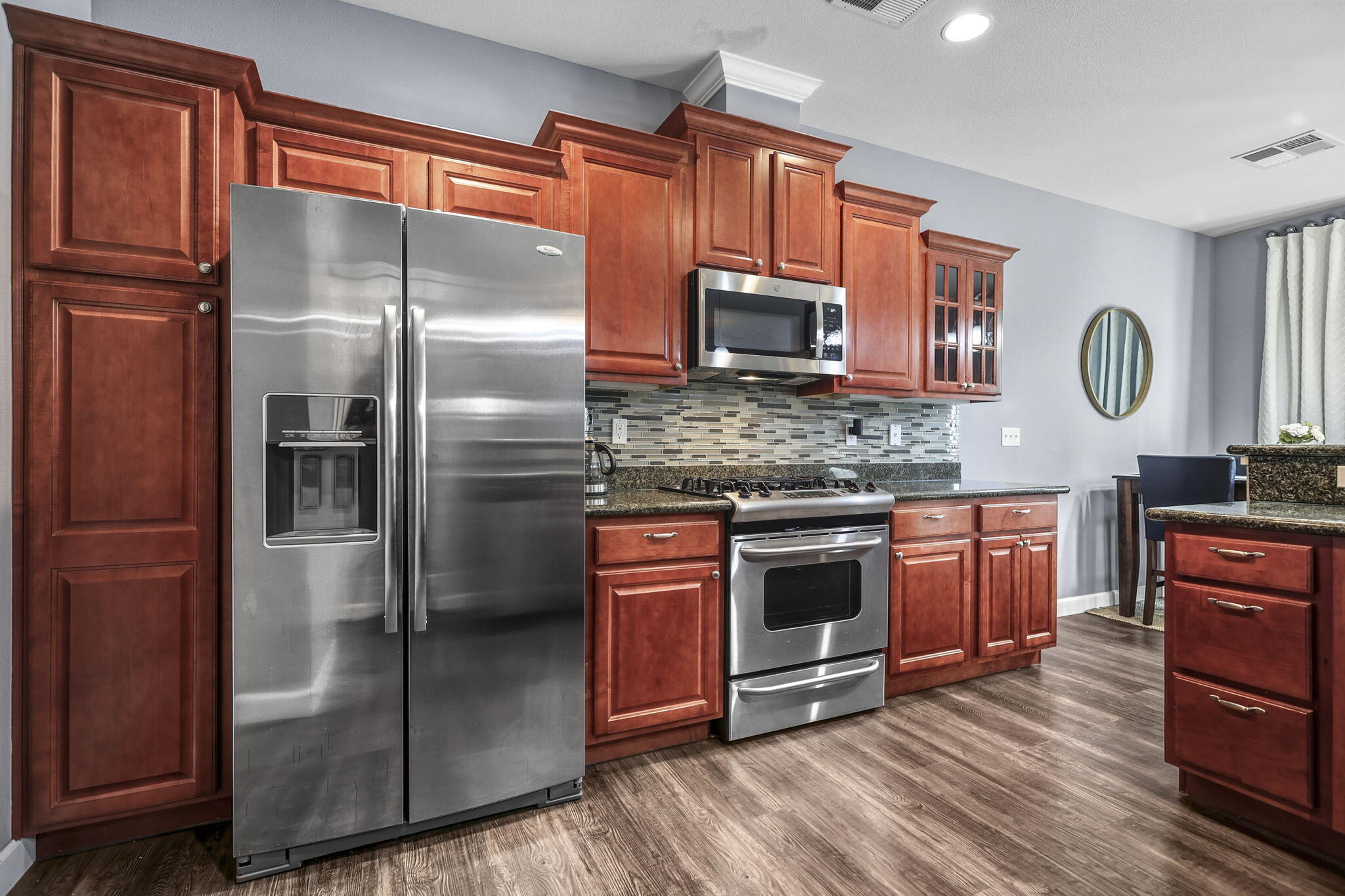 3156 Niklaus Path Redding, CA 96002 - Photo 7 of 34 a kitchen with stainless steel appliances granite countertop a refrigerator a stove top oven a sink and dishwasher