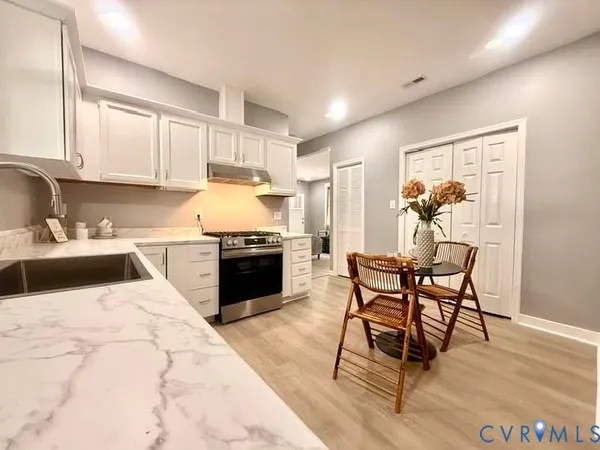 a kitchen with a table chairs sink and cabinets