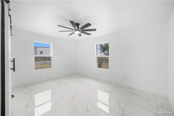 an empty room with a window and a ceiling fan