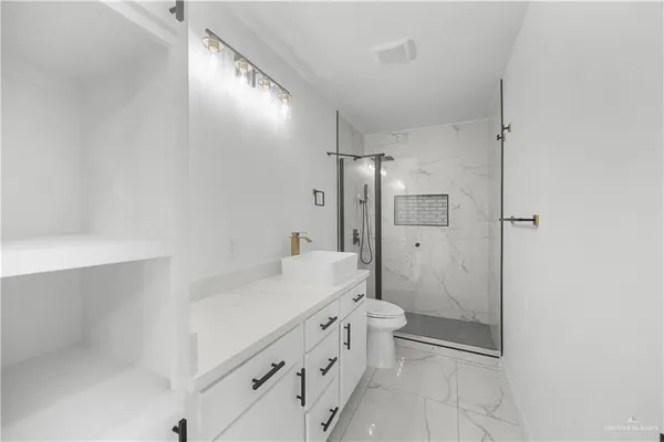 a bathroom with a double vanity sink toilet mirror and shower