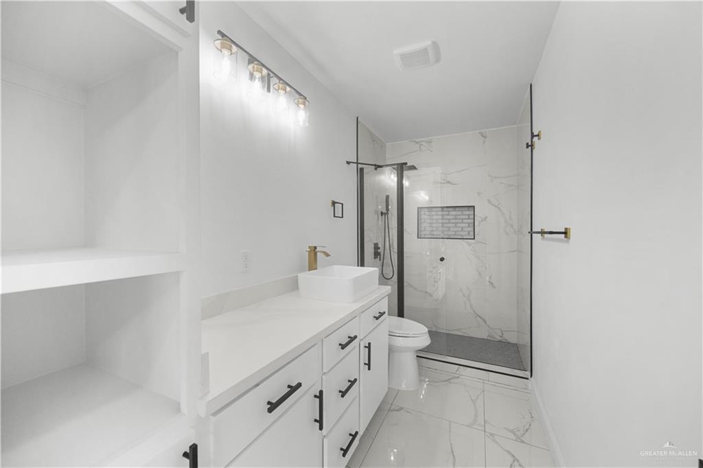 313 West Eller Avenue Pharr, TX 78577 - Photo 7 of 15 a bathroom with a double vanity sink toilet mirror and shower